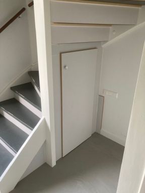 Trap voorzien van stootborden en een kast onder de trap in Made