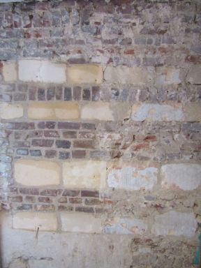 Na het slopen van de oude voorzetwanden vond de opdrachtgever het zonde om de oude muren met speklagen uit mergel achter de tegels te laten verdwijnen.