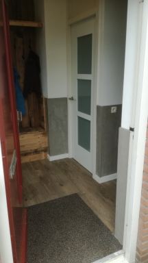 combinatie van beton look met sloophout en hoge plinten geven een mooie uitstraling naast de design deur te  Nuenen