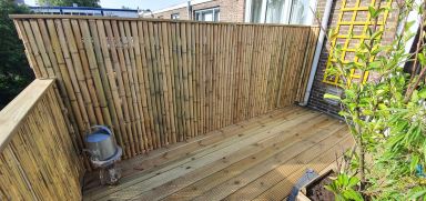 Dakterras met nieuw hekwerk met bamboe en nieuwe vlonderplanken in Dordrecht